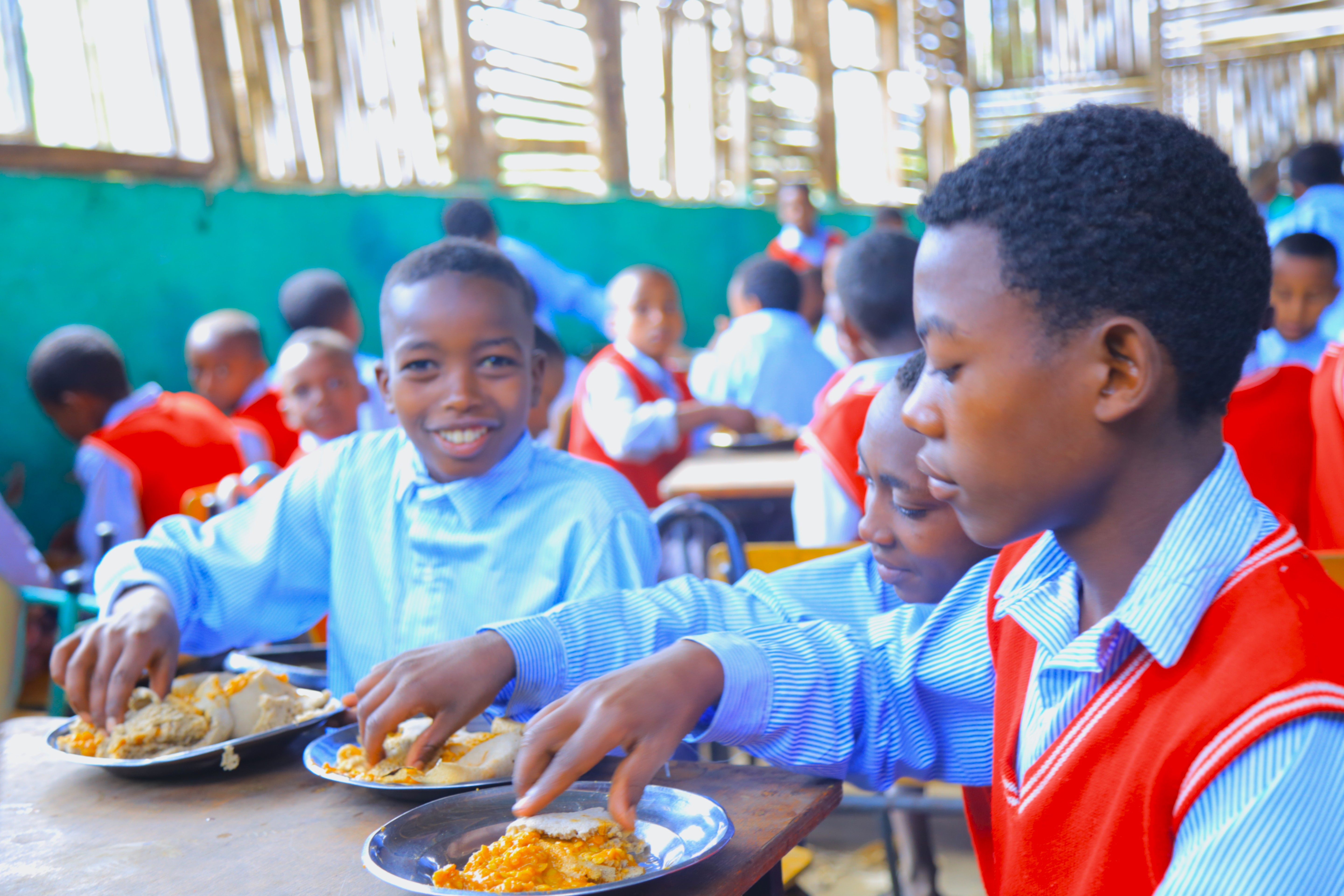 Children happily eating breakfast at school